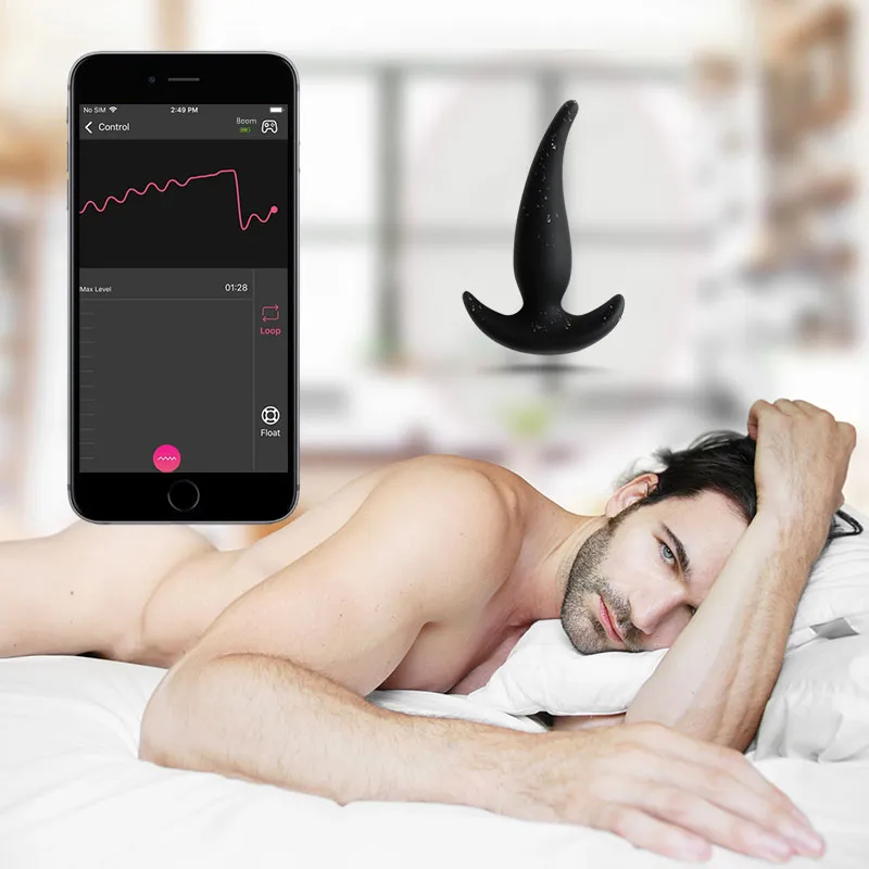 Boom app-controlled anal plug with customizable vibration patterns, shown with a smartphone app interface and a nude man on a bed, highlighting personalized pleasure.
