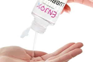 A sensual image of Enjox lubricant being applied to a vibrator, ready for use.